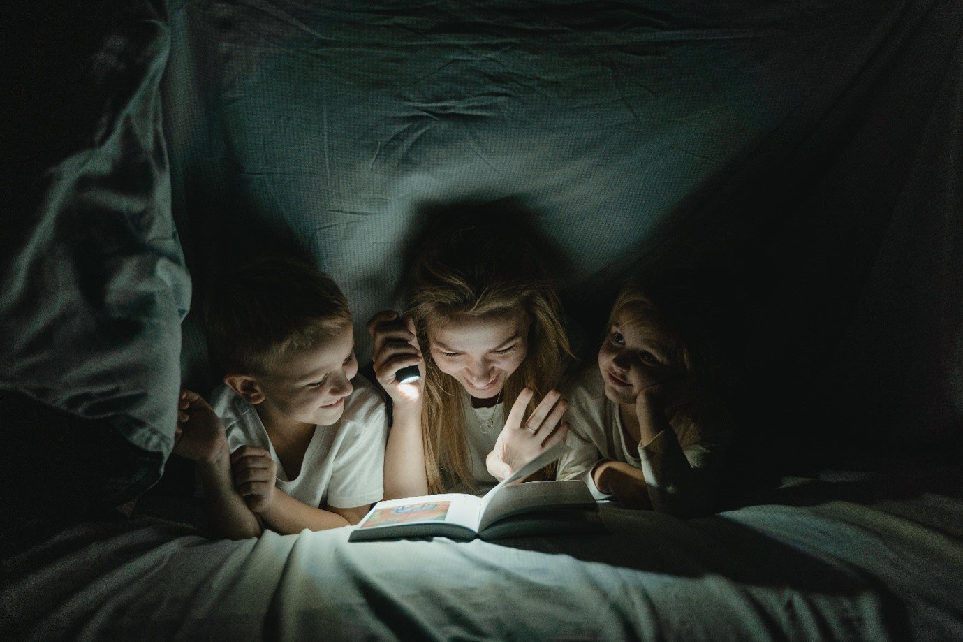mother and daughter reading together at night