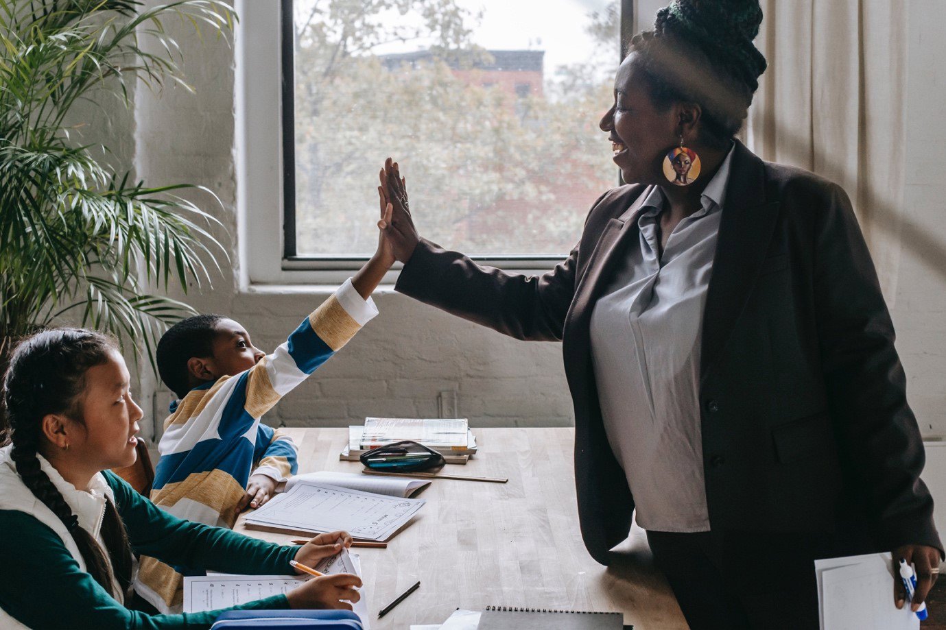 A teacher and school child giving each other a high five