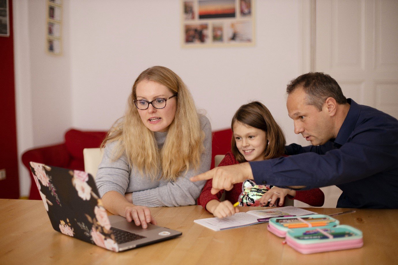a family sat together looking at a laptop