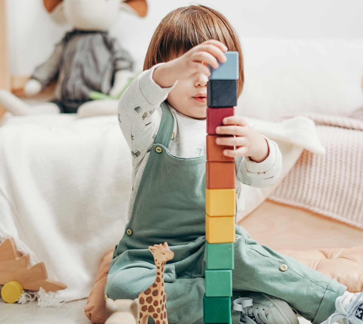child stacking building blocks on top of each other