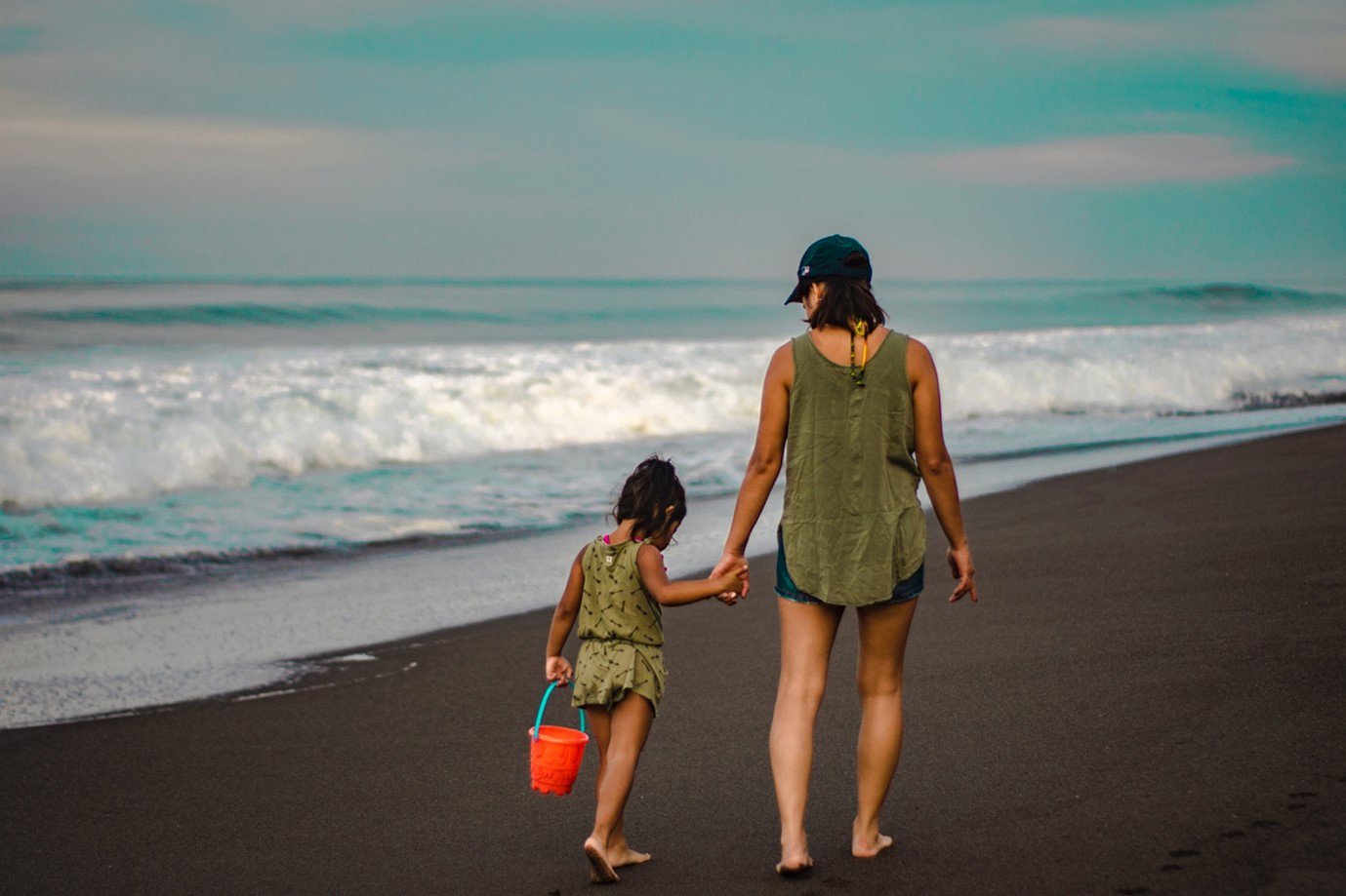 Mother and daughter walking on beach