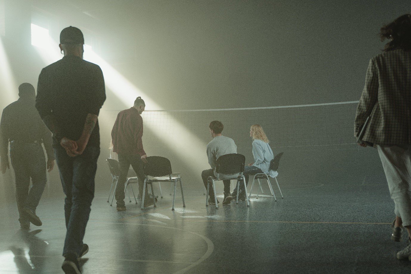 people sat in a circle, with light coming through a window