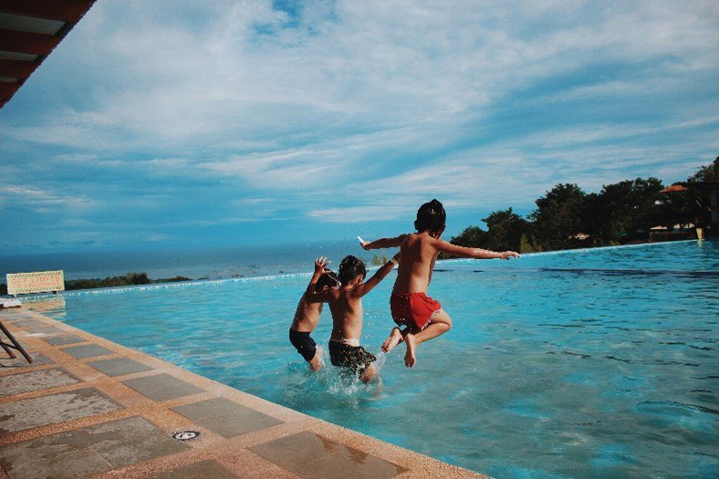 Children jumping in pool