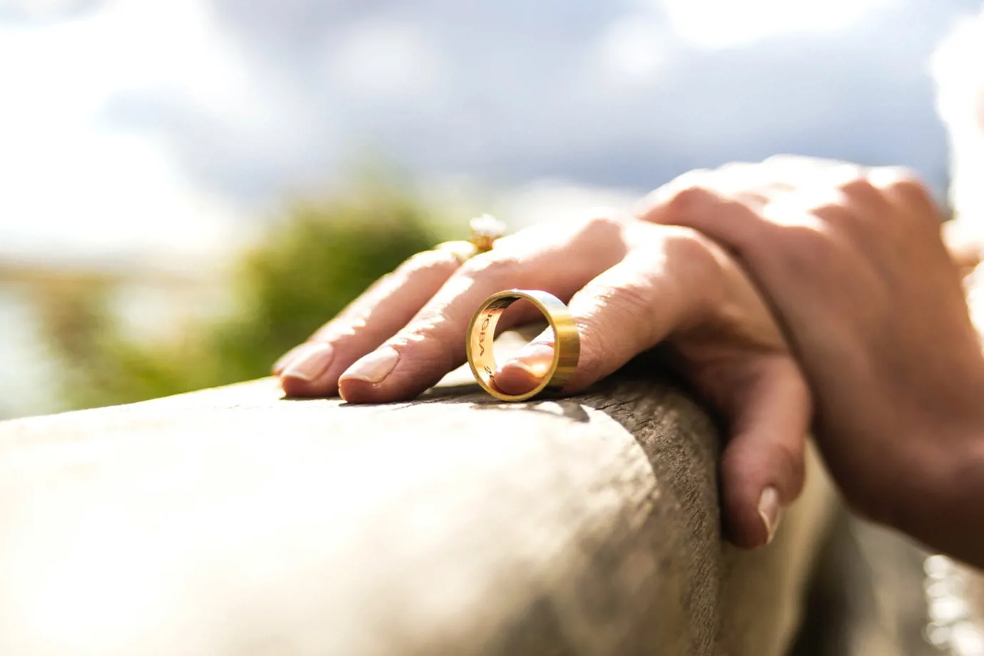 a wedding ring next to a person's hand