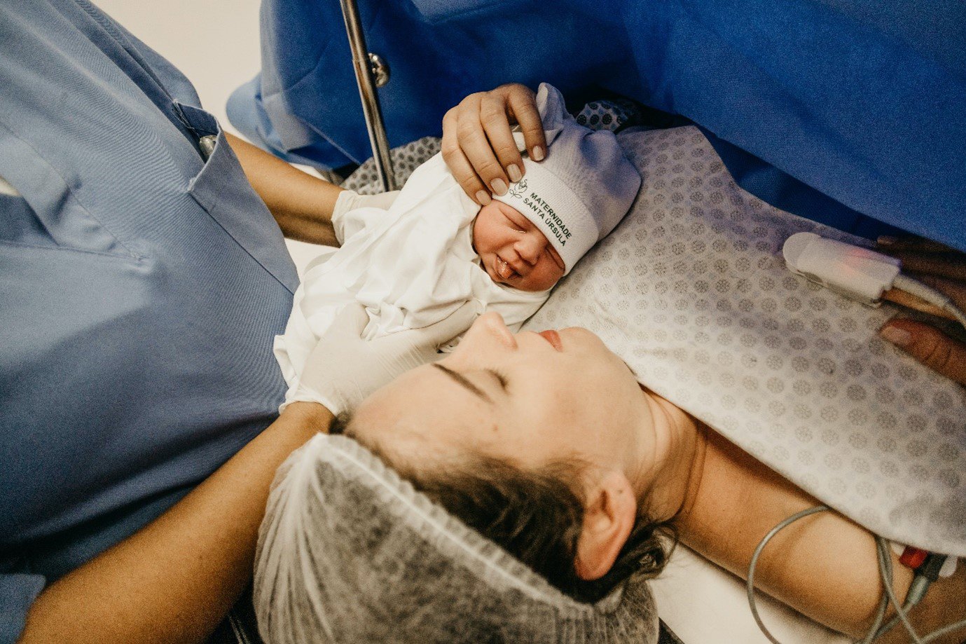 a mother laying with her newborn baby