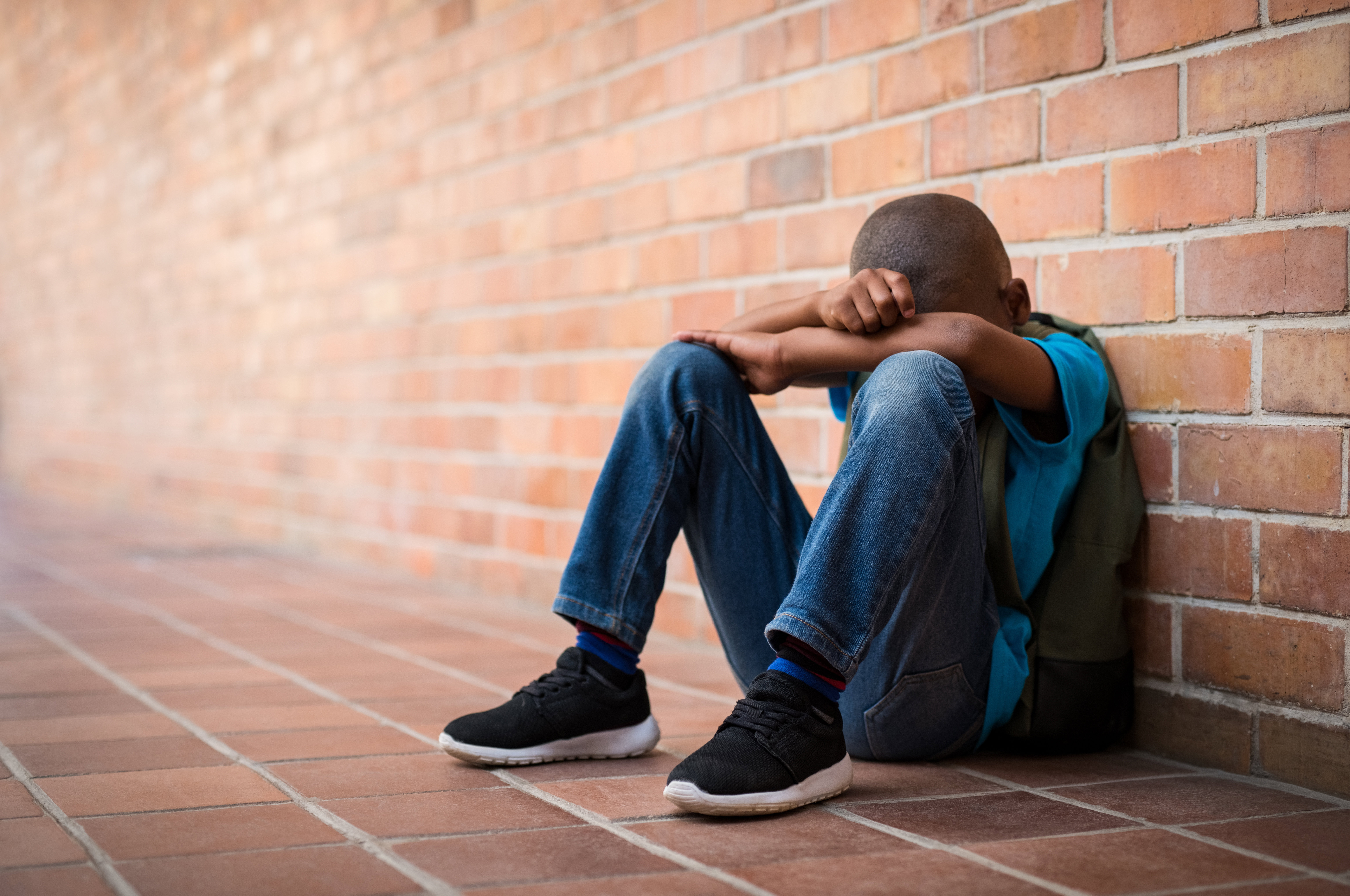 a young boy sat down looking sad