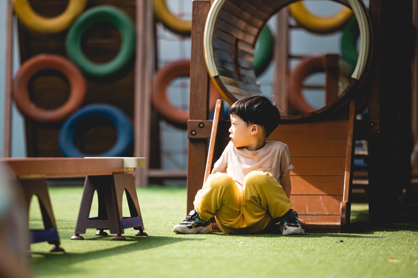 A child sitting on the floor in a playground