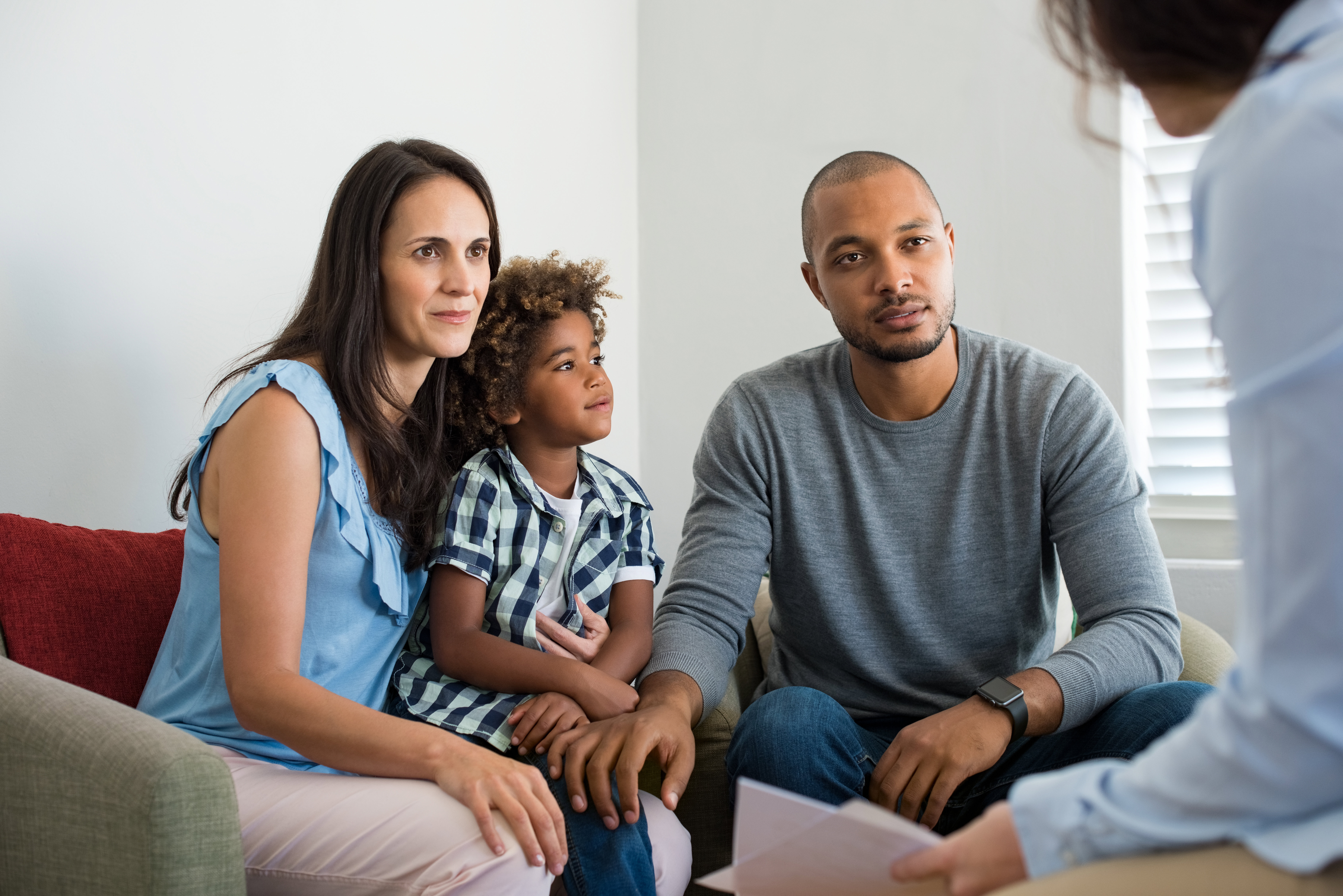 a couple with their child talking to a professional