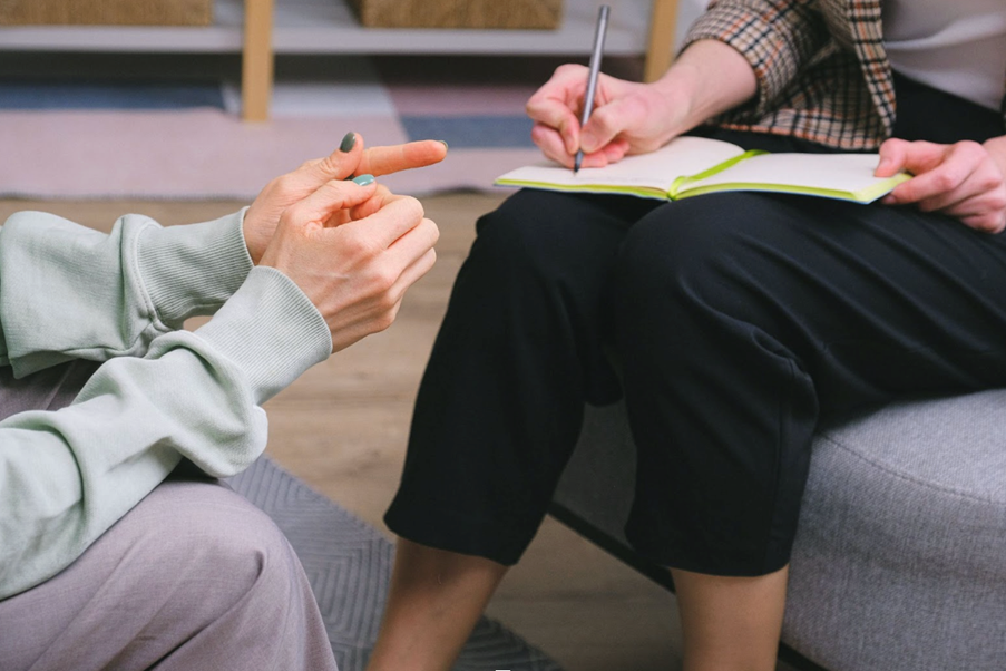 Two people in discussion, one is taking notes