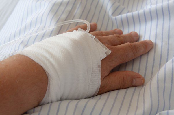 a drip being fed into a patient's hand