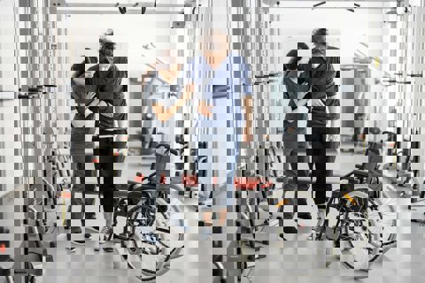 Rehabilitation Specialist helps young man out of wheelchair