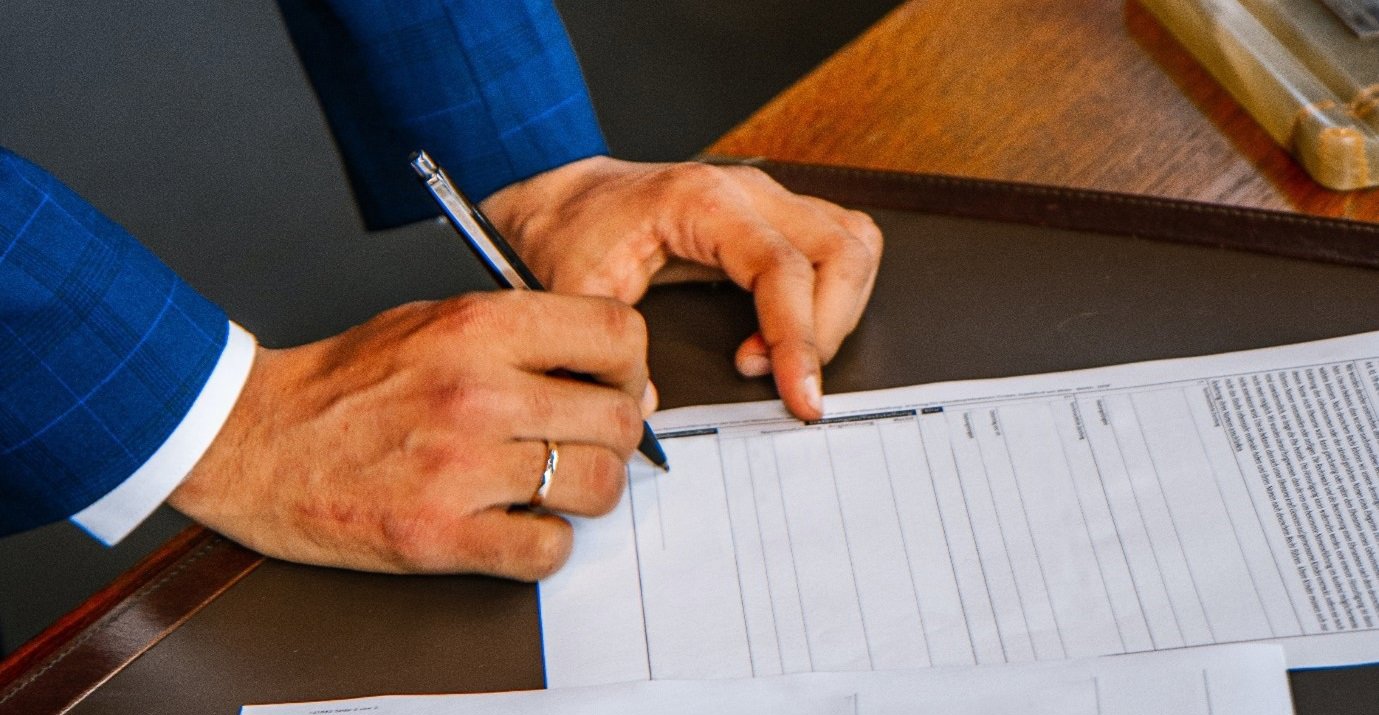 a close up of hands signing a document